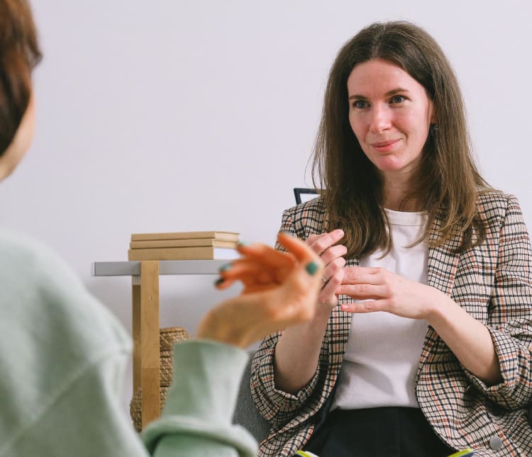 A woman sitting in front of another person.